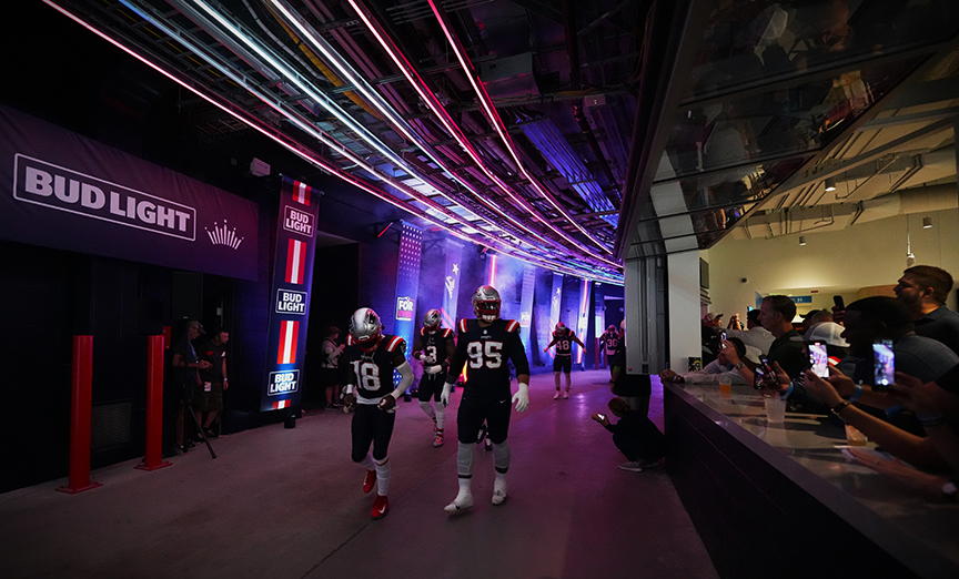 Two Patriots players walking through the Celebration Beer Hall.