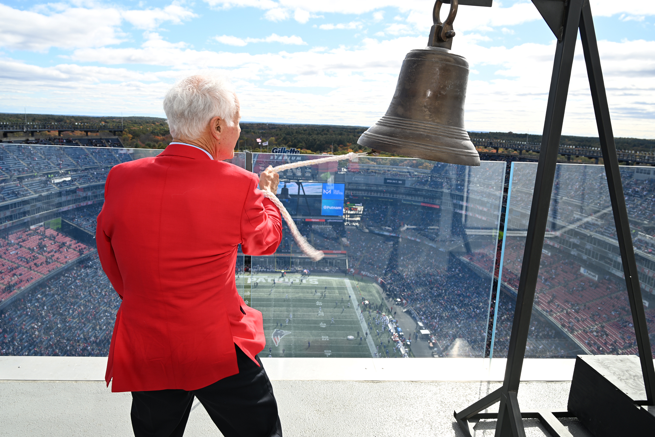 Dante Scarnecchia wearing a red blazer, giving his back to the camera, and ringing the bell. Dante was keeper of the light on October 22.