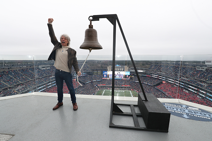 Jon Bon Jovi yelling with his right arm up in the sky, and his left arm ringing the bell. Jon Bon Jovi was the keeper of the light on December 17.