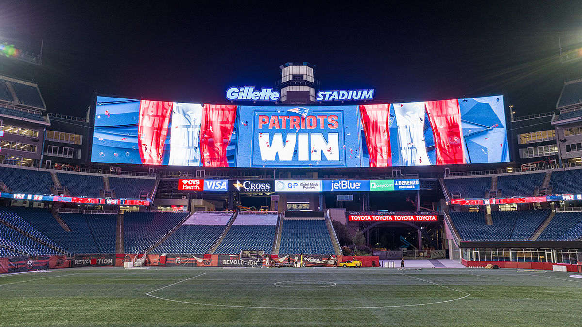 Scoreboard at night with the words 'Patriots Win' on it.
