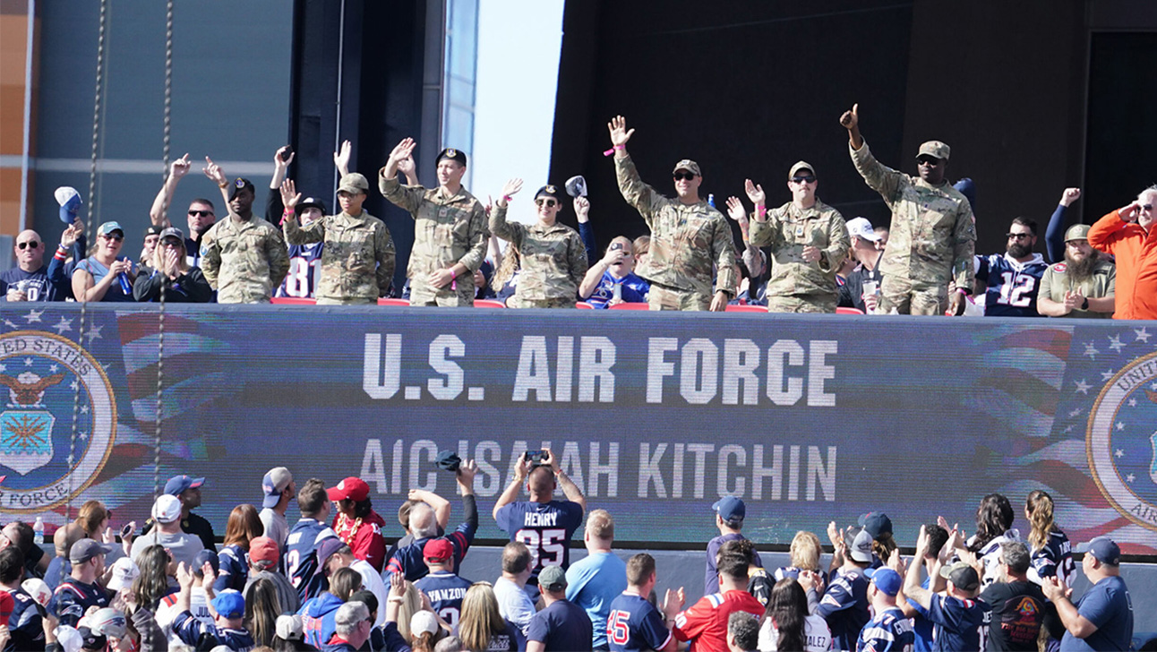 U.S. Air Force members waving at the crowd on a Patriots game day.
